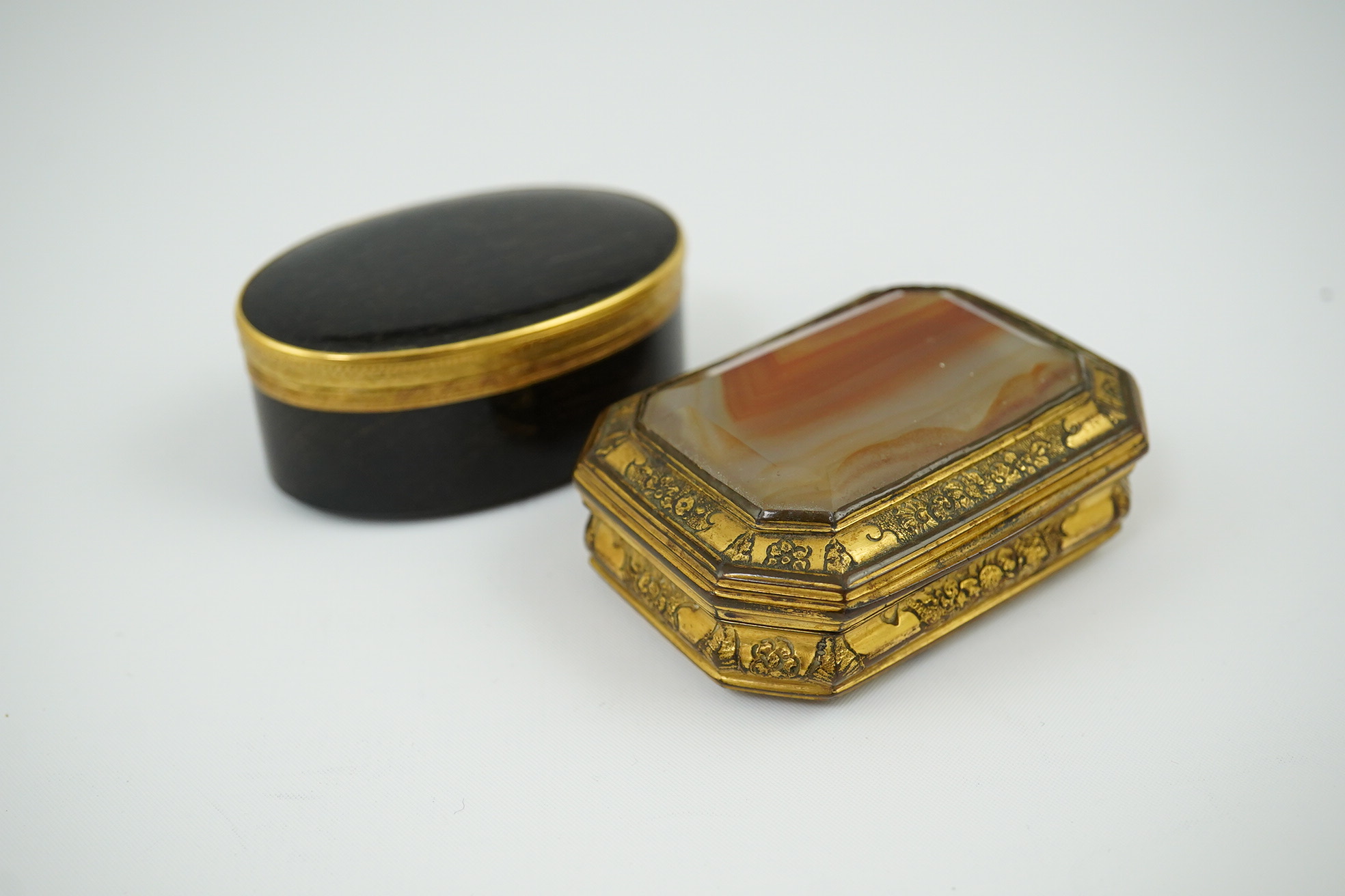 An early 19th century German gold mounted rutile agate? oval snuff box, 64mm and another gilt copper mounted agate snuff box.